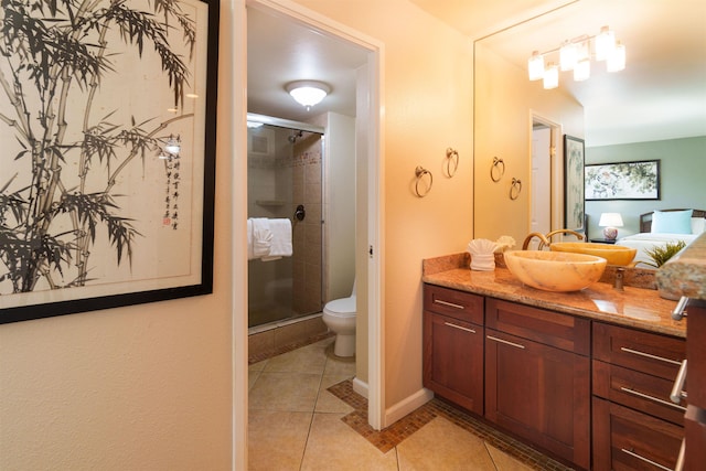 bathroom featuring tile patterned floors, a shower stall, toilet, vanity, and baseboards