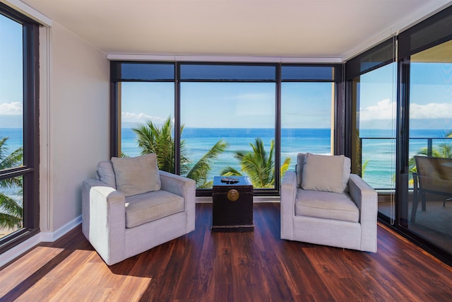sunroom featuring a water view