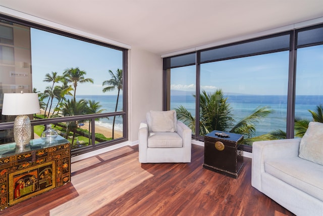 living area with floor to ceiling windows, a water view, and dark wood-style floors