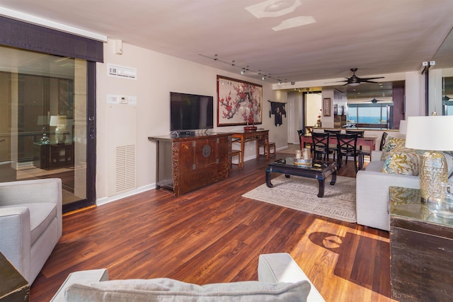 living area with visible vents, ceiling fan, baseboards, rail lighting, and wood finished floors