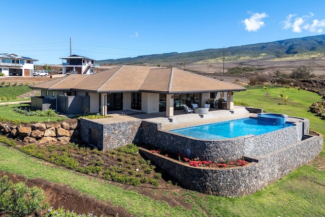 view of pool featuring a mountain view, an in ground hot tub, and a patio area