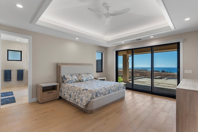 bedroom with access to outside, a raised ceiling, and ceiling fan