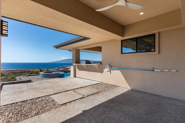 view of patio with ceiling fan and a water view