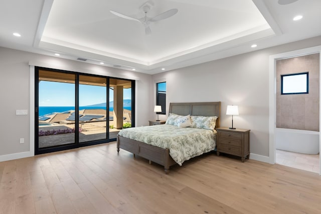 bedroom with access to outside, a raised ceiling, and ceiling fan