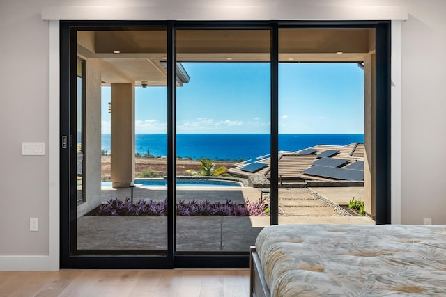 bedroom featuring a water view and wood-type flooring