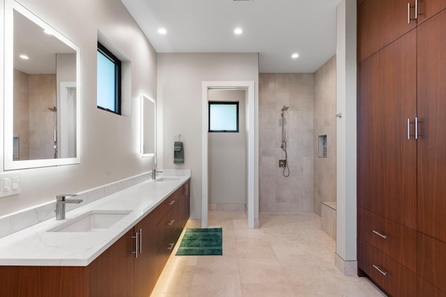 bathroom with tiled shower, vanity, tile patterned floors, and a wealth of natural light