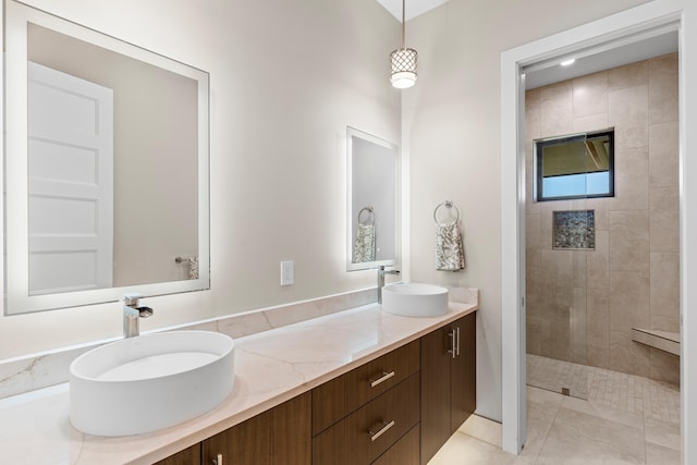 bathroom featuring tile patterned flooring, vanity, and tiled shower