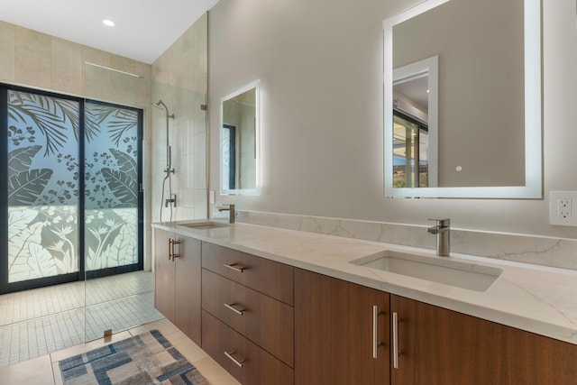 bathroom with tile patterned flooring, vanity, and tiled shower