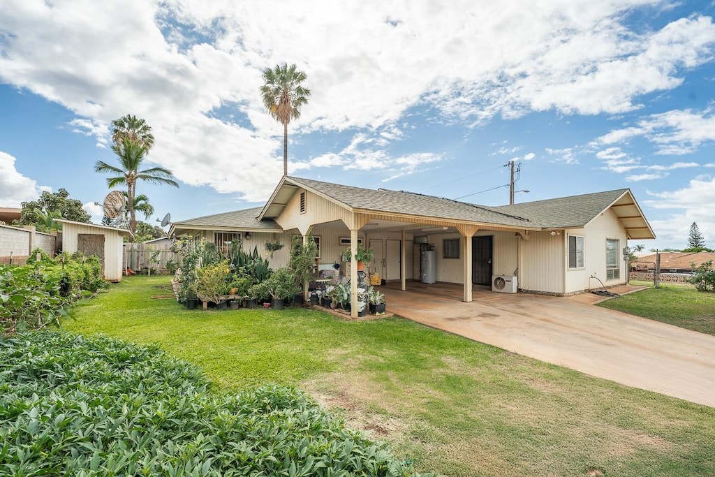 view of front of home featuring a storage unit, a carport, and a front yard