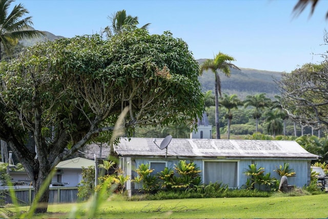 view of property exterior featuring a mountain view and a lawn