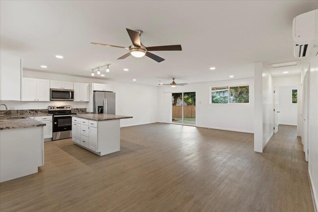 kitchen with white cabinets, a kitchen island, sink, and stainless steel appliances