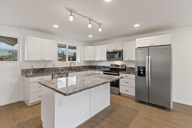 kitchen with white cabinets, a center island, sink, and stainless steel appliances