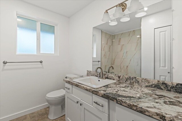 bathroom with a shower, vanity, and toilet