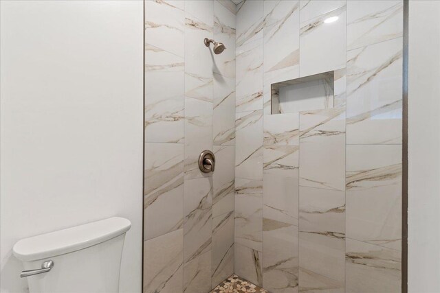 bathroom with toilet and tiled shower