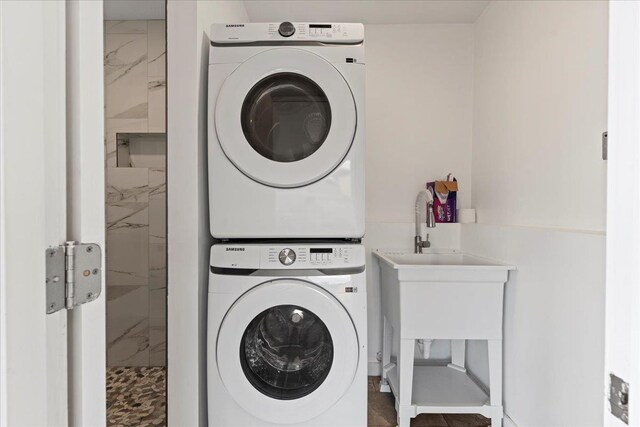 clothes washing area with stacked washer and clothes dryer