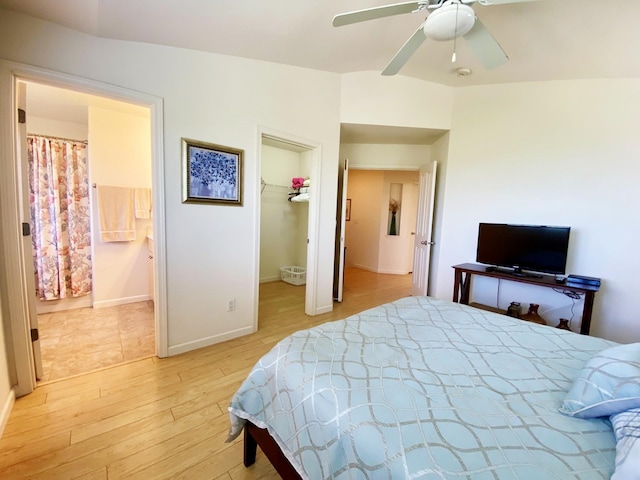 bedroom with a spacious closet, a closet, ensuite bathroom, light hardwood / wood-style floors, and ceiling fan