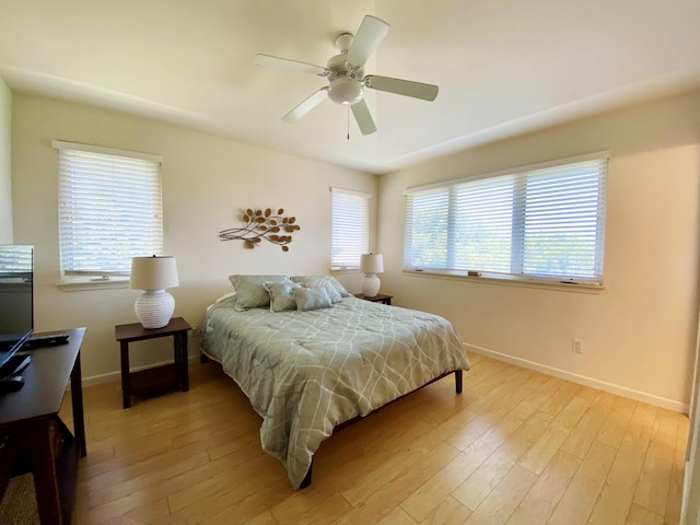 bedroom with light hardwood / wood-style flooring, ceiling fan, and multiple windows