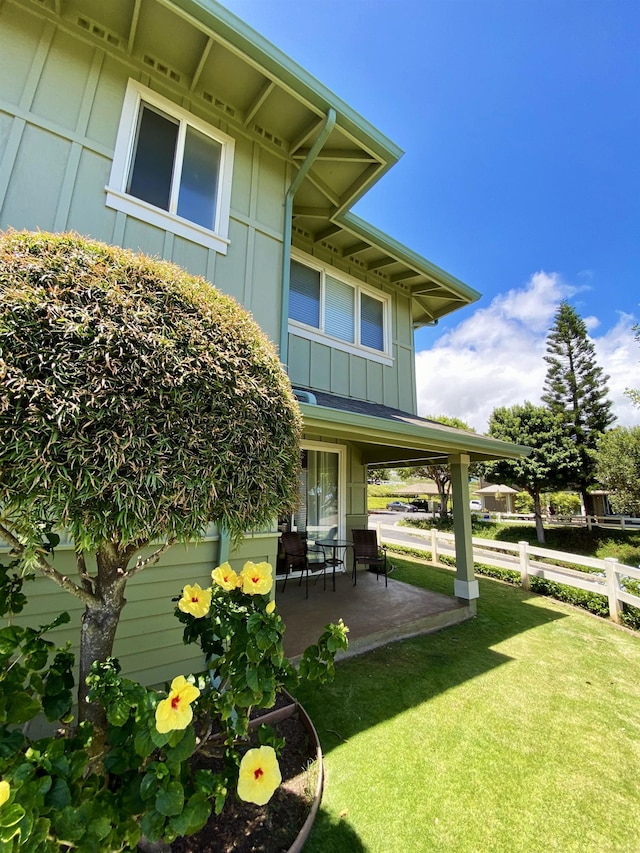 view of side of property with a yard and a patio