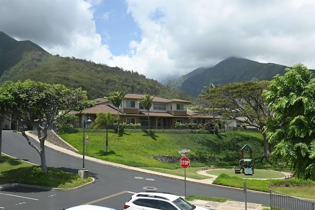 view of street with curbs, a mountain view, and traffic signs