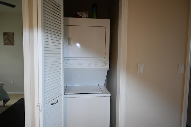 clothes washing area featuring stacked washer / drying machine and laundry area