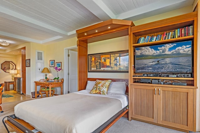 bedroom with beam ceiling and light colored carpet