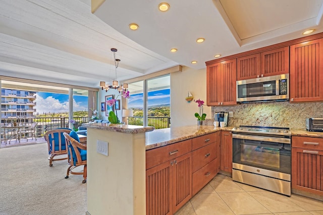 kitchen featuring decorative backsplash, kitchen peninsula, appliances with stainless steel finishes, and decorative light fixtures