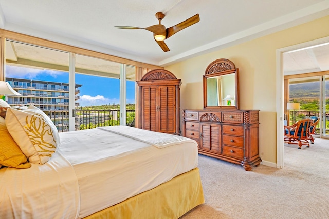 bedroom with multiple windows, ceiling fan, and access to exterior