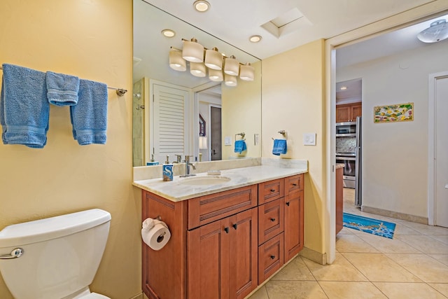 bathroom with vanity, tile patterned flooring, and toilet