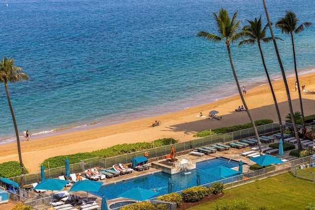 view of swimming pool featuring a view of the beach and a water view