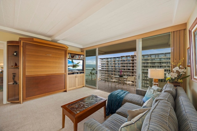 carpeted living room featuring beam ceiling