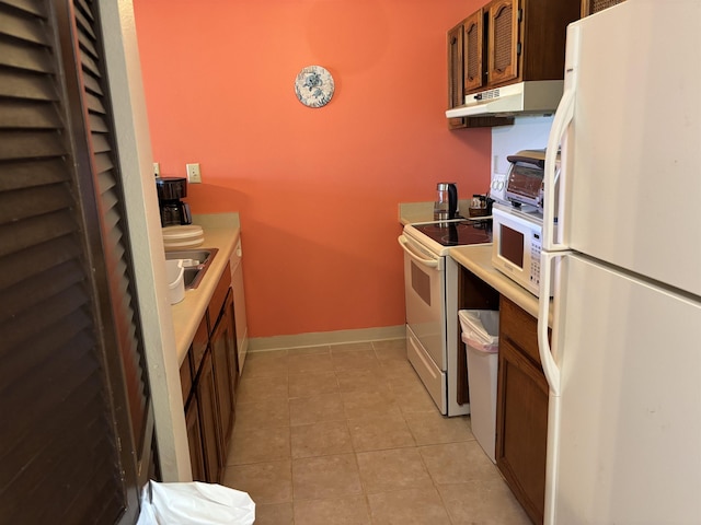 50 Kepuhi Pl Unit 159, Maunaloa, HI 96770 - kitchen with white appliances, under cabinet range hood, light tile patterned flooring, baseboards, and a sink