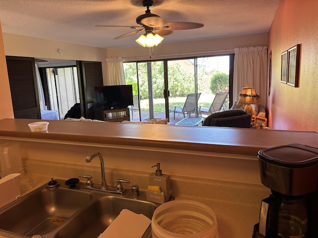 50 Kepuhi Pl Unit 159, Maunaloa, HI 96770 - kitchen with a textured ceiling, a sink, a textured wall, ceiling fan, and open floor plan
