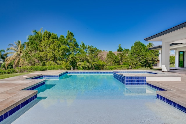 view of swimming pool featuring a patio area and an in ground hot tub