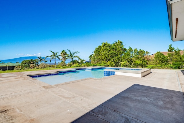 view of swimming pool featuring an in ground hot tub, a mountain view, and a patio