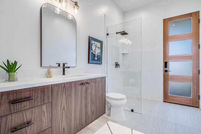 bathroom featuring a tile shower, tile patterned floors, vanity, and toilet