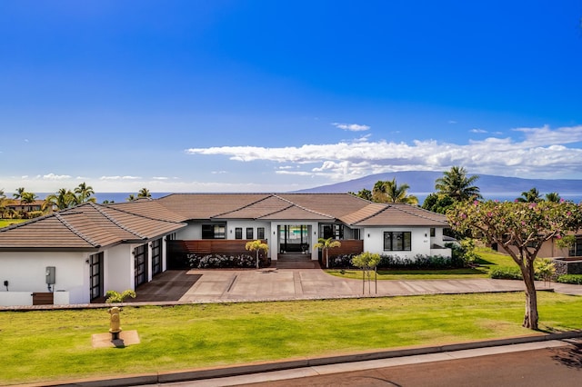 ranch-style home featuring a mountain view, a garage, and a front lawn