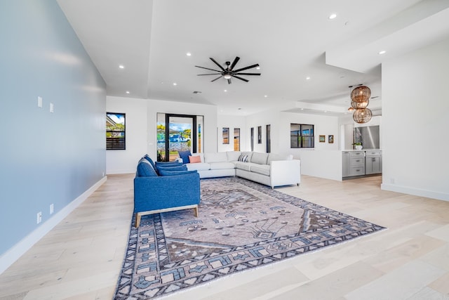 living room with ceiling fan and light hardwood / wood-style flooring