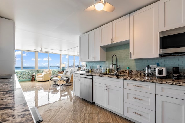 kitchen with stainless steel appliances, ceiling fan, a sink, and backsplash