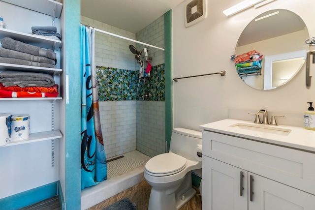 bathroom featuring a shower stall, toilet, and vanity