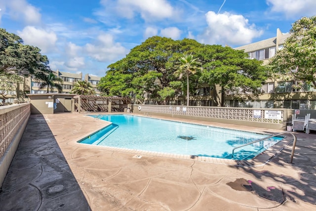 community pool featuring fence and a patio area