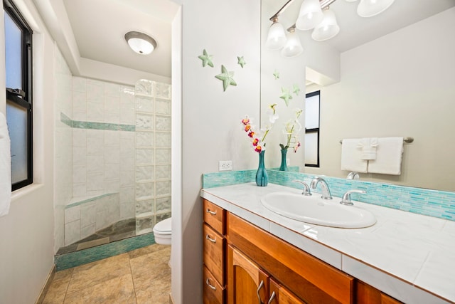 bathroom with tiled shower, backsplash, vanity, and toilet