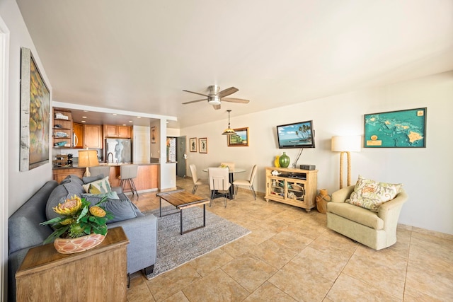 living room with ceiling fan, light tile patterned flooring, and sink