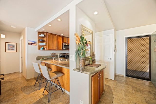 kitchen with kitchen peninsula, a breakfast bar area, and sink