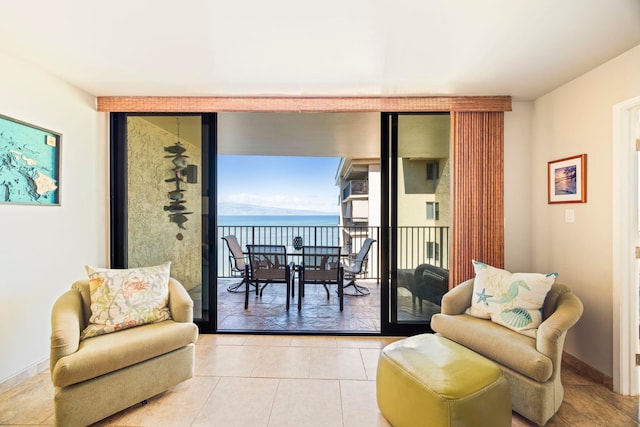 living area featuring a water view and light tile patterned flooring