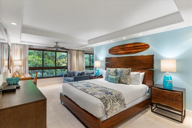 bedroom featuring a raised ceiling and light colored carpet