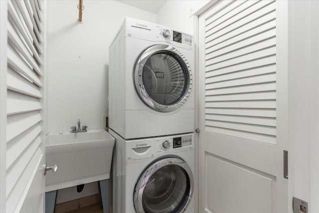 laundry room with stacked washer / dryer and sink