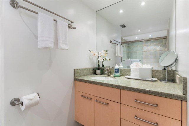 bathroom with walk in shower, vanity, and tasteful backsplash