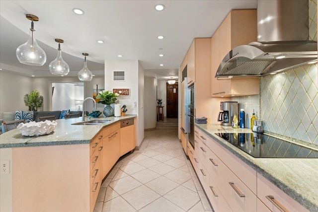 kitchen with hanging light fixtures, sink, wall chimney exhaust hood, appliances with stainless steel finishes, and light brown cabinetry