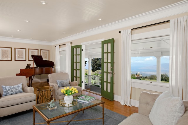 living room featuring wood-type flooring, ornamental molding, and french doors