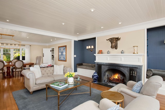 living room with a premium fireplace, ornamental molding, wooden ceiling, and hardwood / wood-style flooring